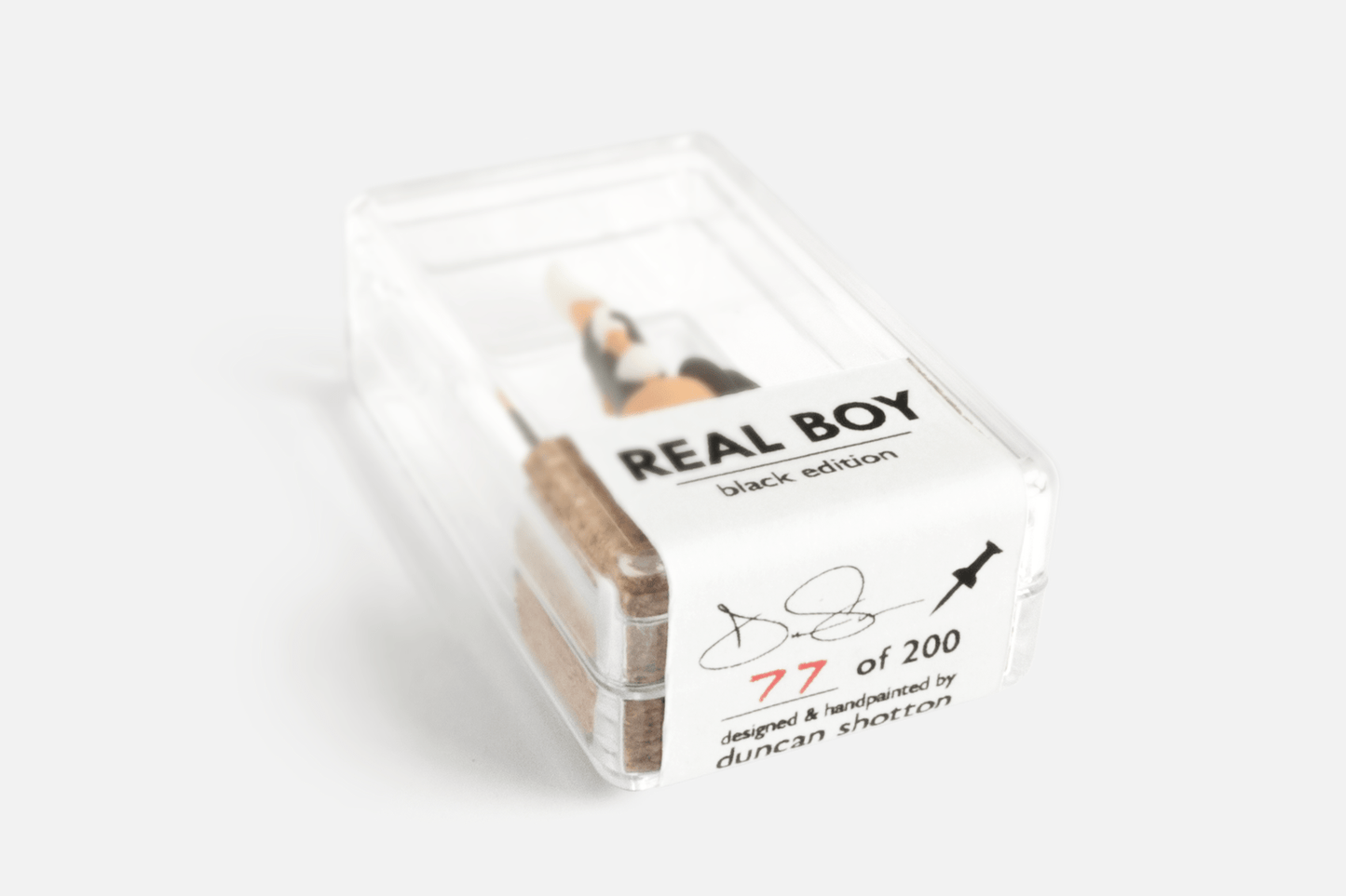 Base of a Real Boy Push Pin (Black edition) in it's display case showing limited edition number 77 of 200