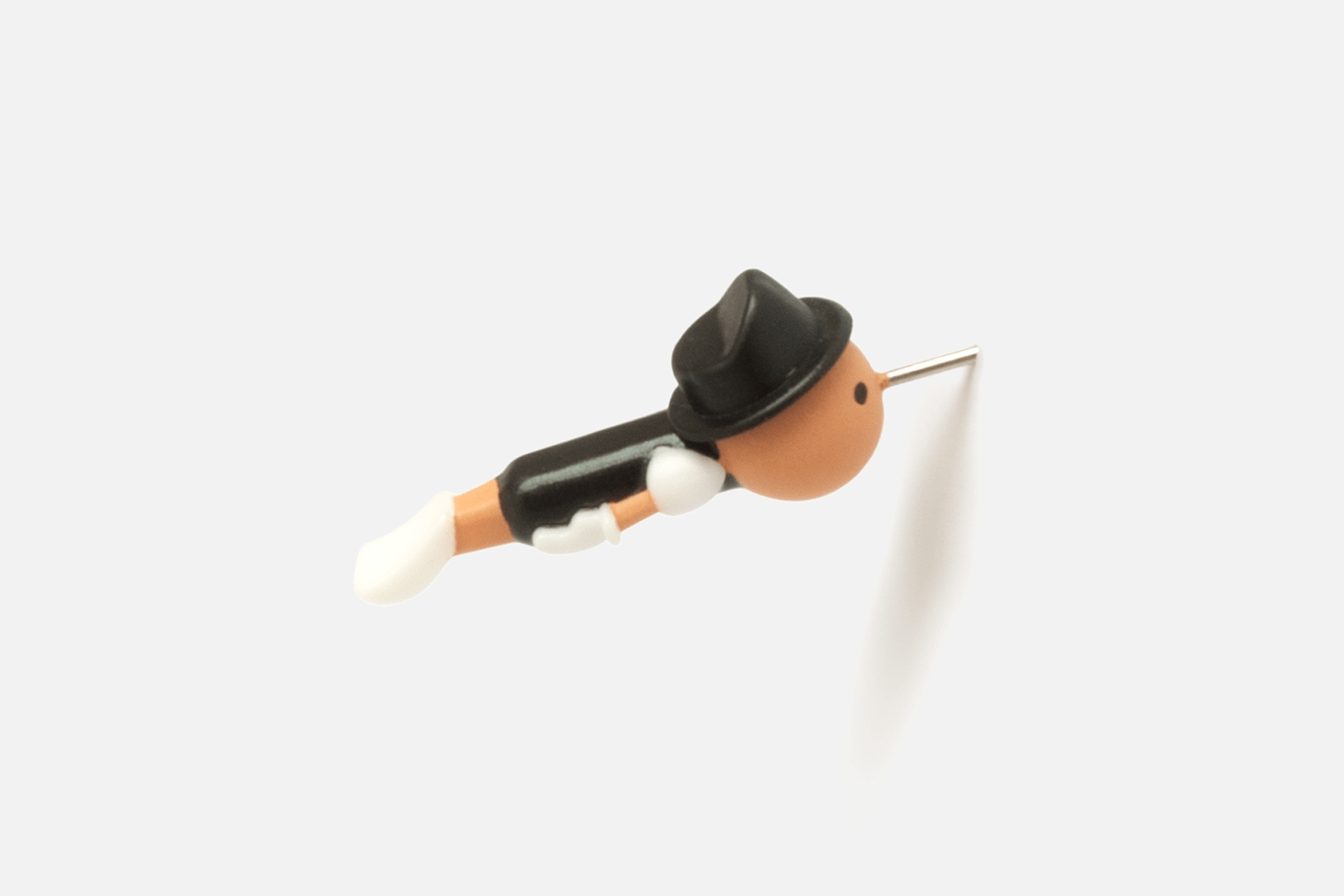 Real Boy Push Pin (Black edition) by Duncan Shotton, pinned into plain surface