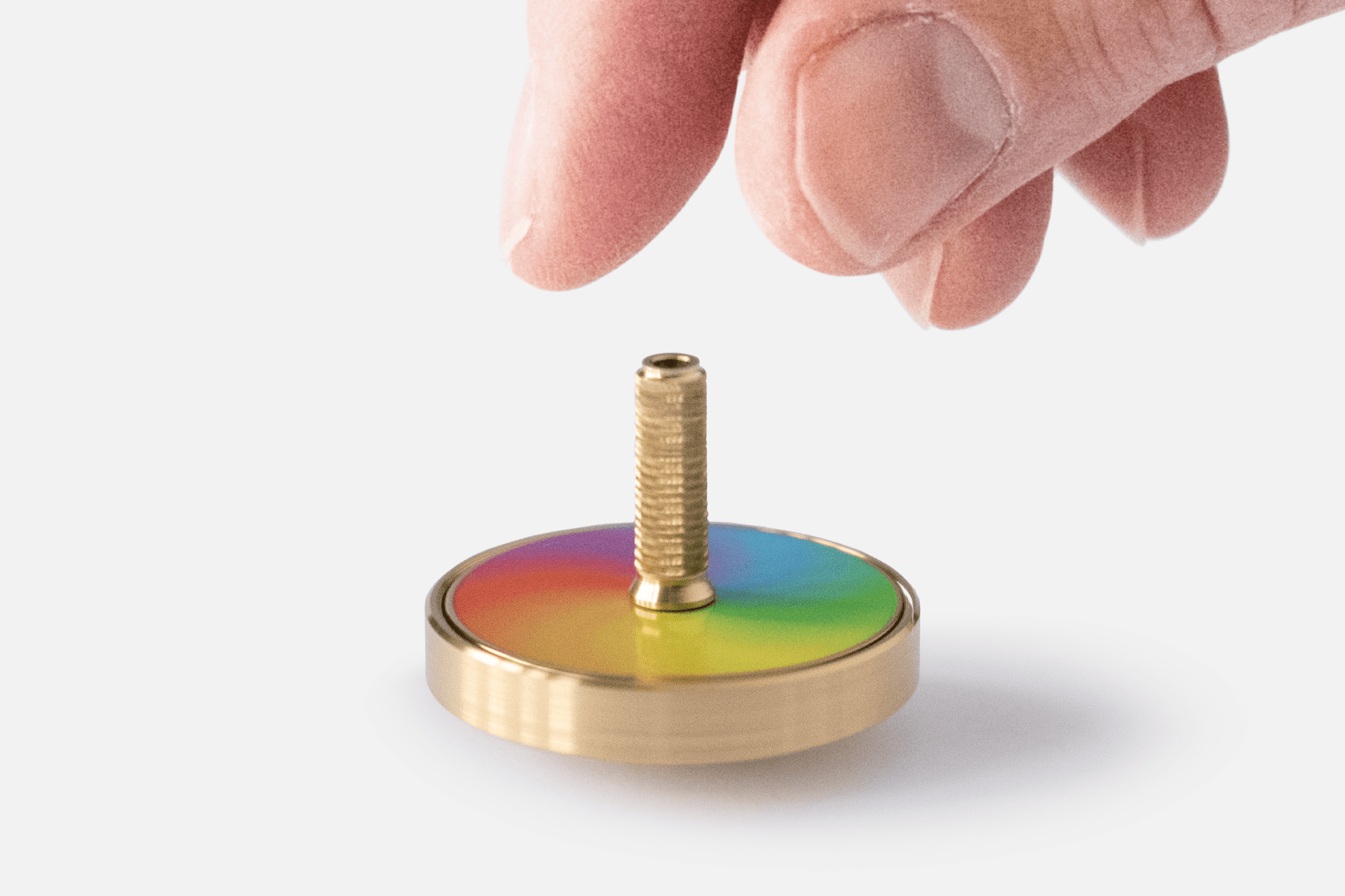 Spinning (desk)top, mid spin, with fingers just above suggesting it has just been released