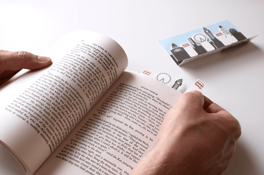 Book lover setting a sticky page marker onto an important page in a book