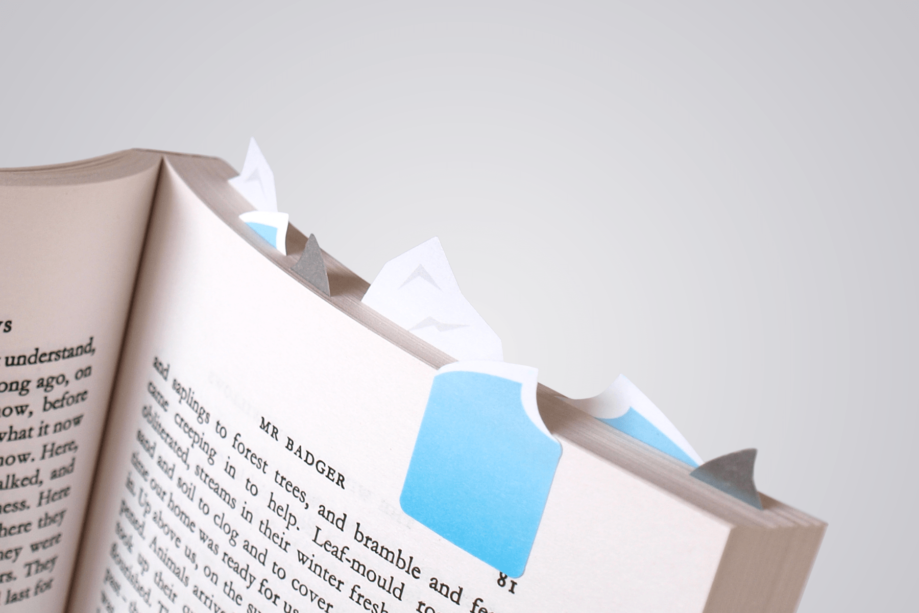 paper bookmark sharks icebergs and waves create an ocean scene on top of a book