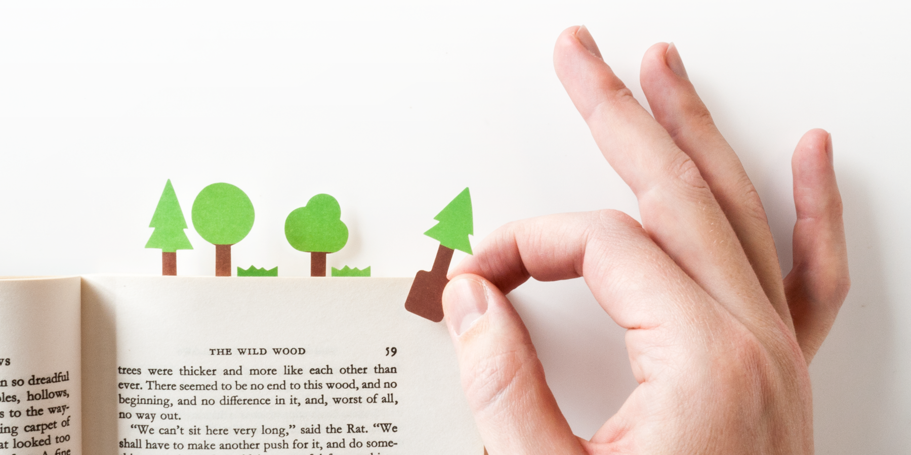 tiny paper tree being set in a book to mark the page