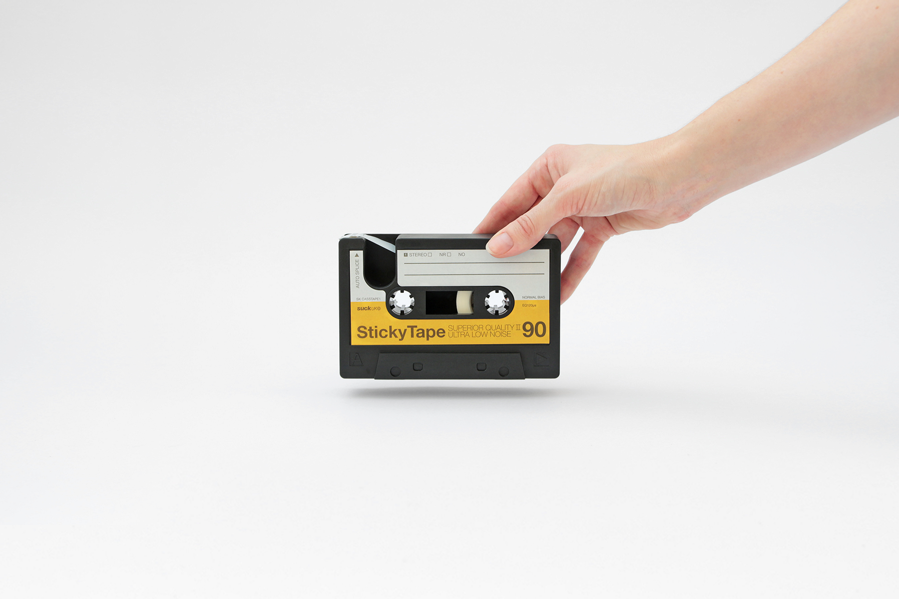 hand holding sticky tape casette dispenser with cutter pointing away