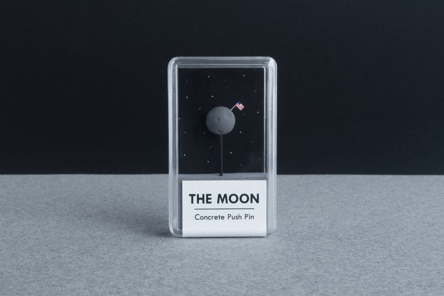 The Moon - Concrete Push Pin - sat on 'moon' grey surface with black background