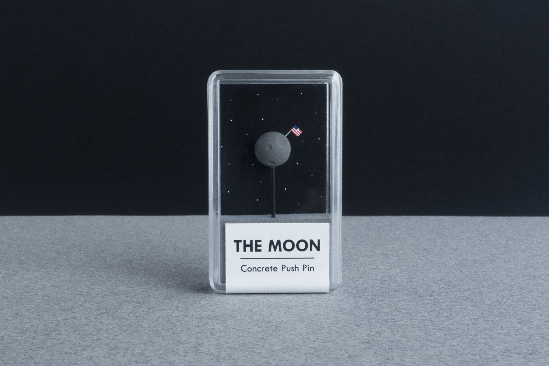 The Moon - Concrete Push Pin - sat on 'moon' grey surface with black background