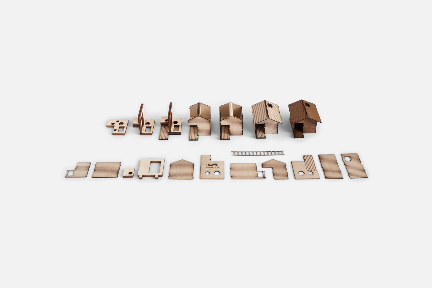 7 stages of treehouse assembly laid out on a flat white surface with the 12 individual parts set out neatly in front.