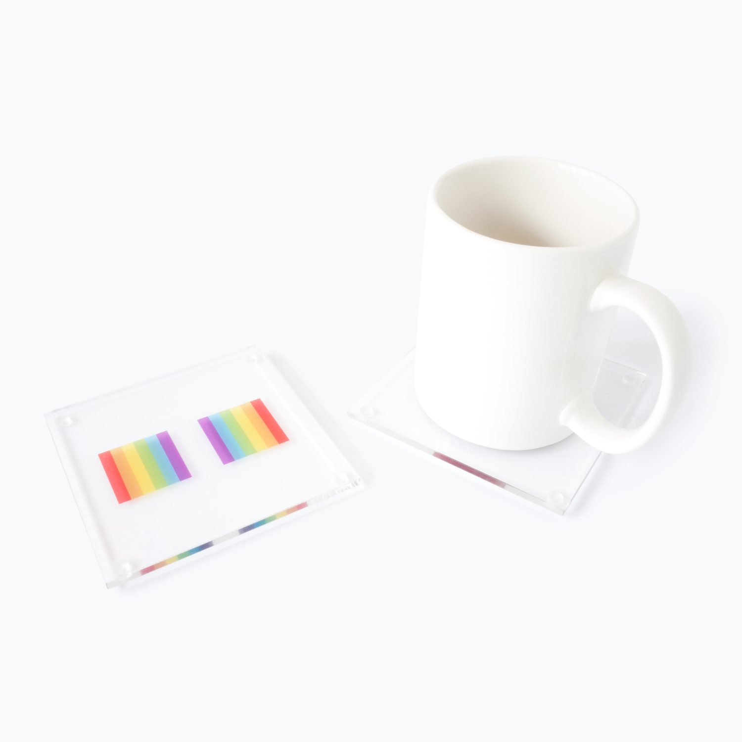 Glass coasters printed with rainbow sections and with a mug on one of them