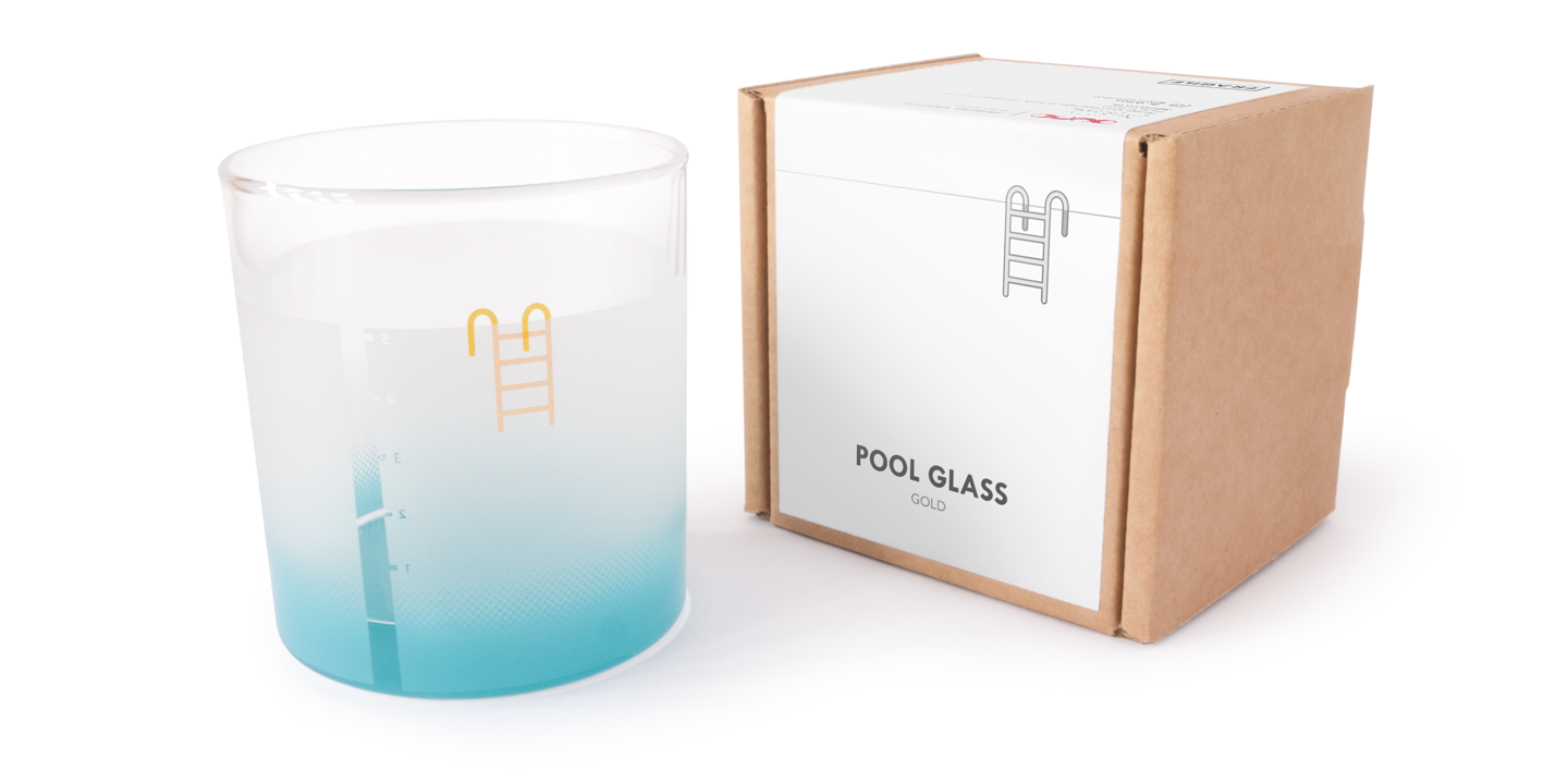 A drinking glass printed with details to make it look like a mini swimming pool (golden ladder, frosted wall, depth gauge) Shown next to a minimal packaging design made of recyclable cardboard and paper. The label reads POOL GLASS - GOLD