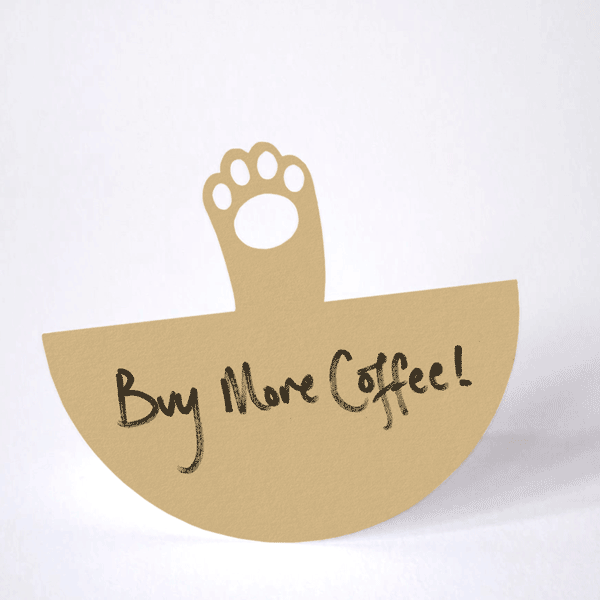 cat paw cut from brown paper rocking back and forth in a waving action on it's circular base. The to-do note inscribed on it reads "Buy More Coffee!"