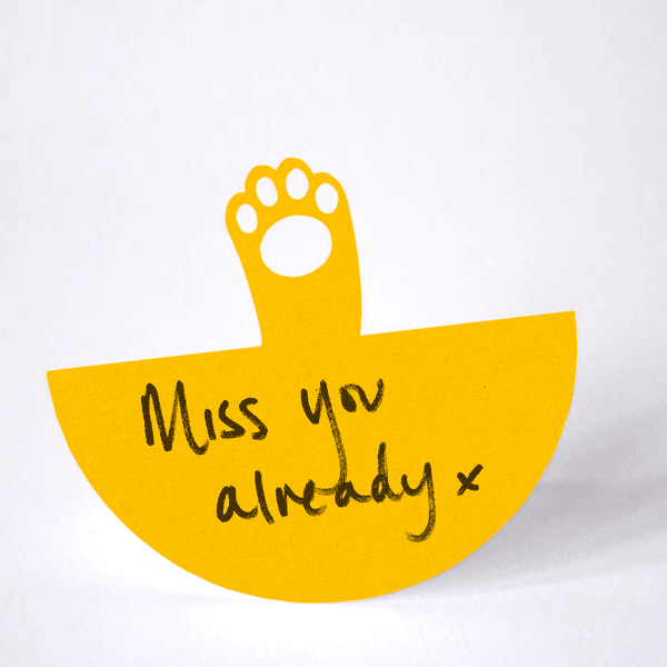 paper gingery orange cat paw rocking from side to side in a waving action on it's arced base