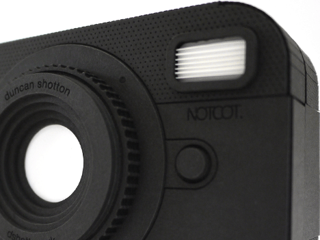 Model of a black camera made from black and white laser cut paper