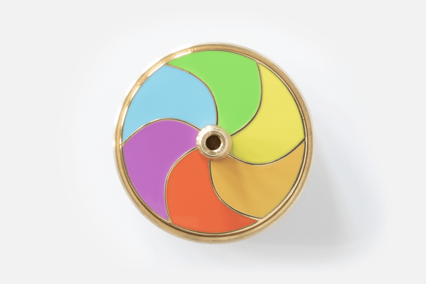 Birds eye view of Spinning (desk)top by Duncan Shotton Design Studio showing six colours of polished enamel piece and central spinning handle