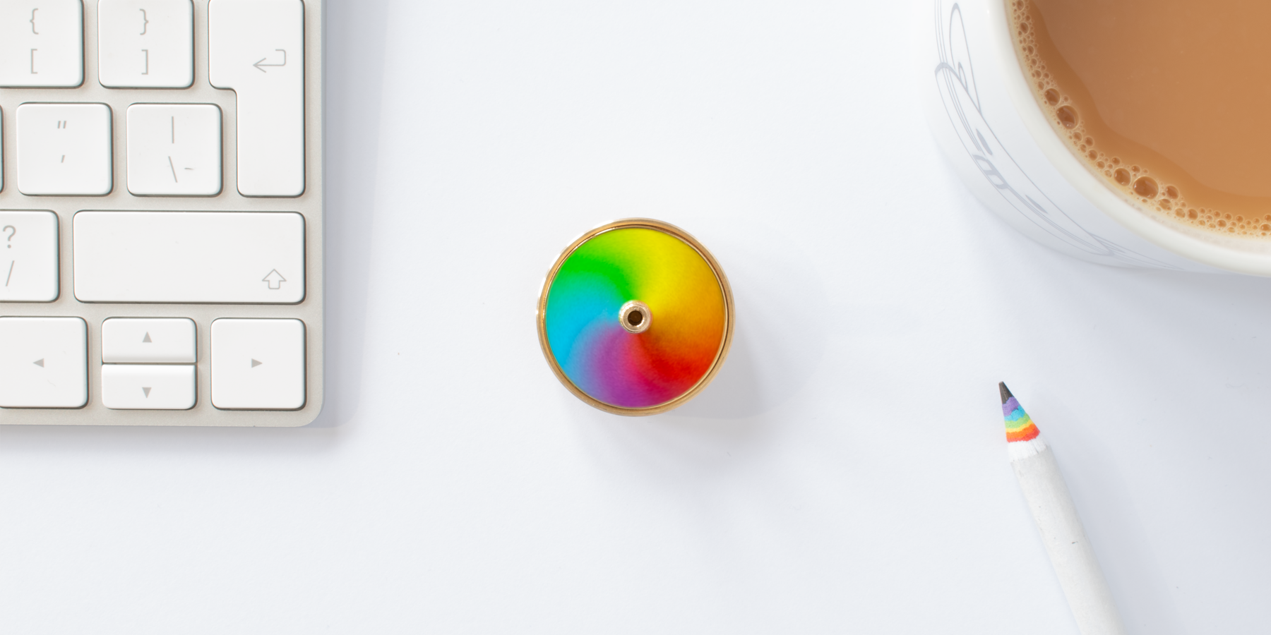 Spinning top shown in context of an office deask, mid spin, with it's rainbow of colours blurring into one another
