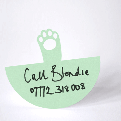 mint green paper cat paw rocking from back and forth in a waving action on it's round base